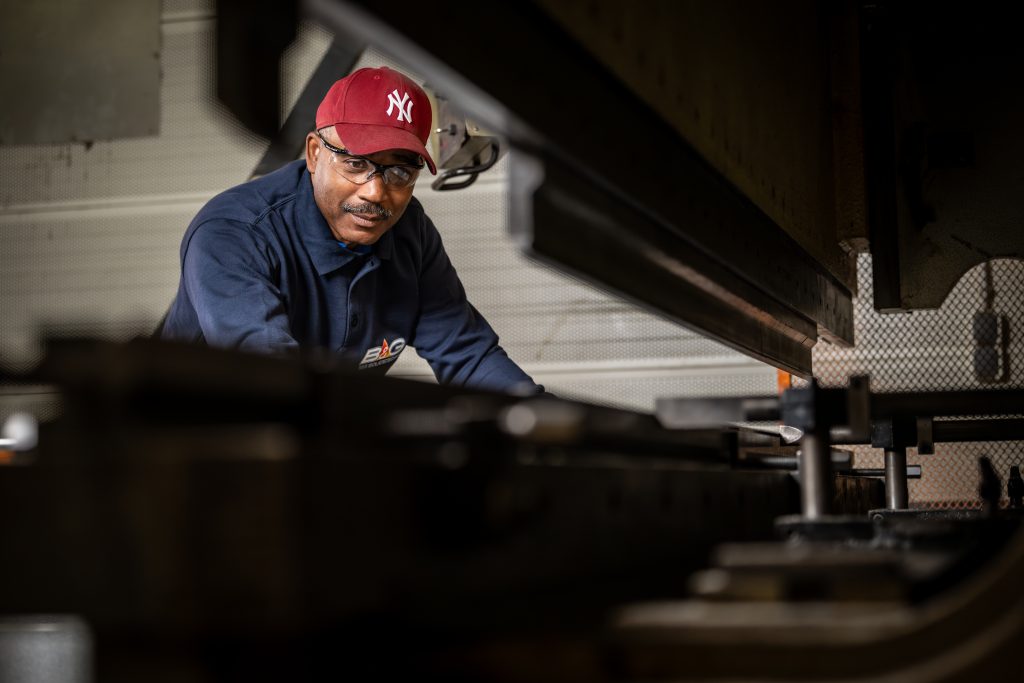 Man met veiligheidsbril werkt aan machine