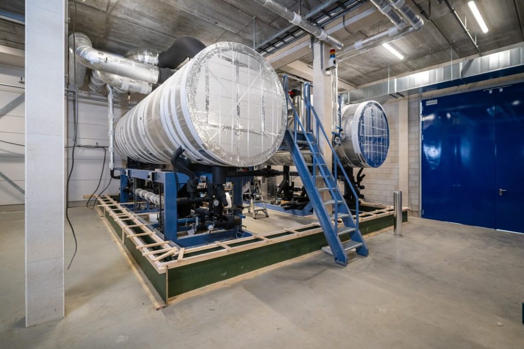 Industriële luchtinstallatie in machineruimte met leidingen.