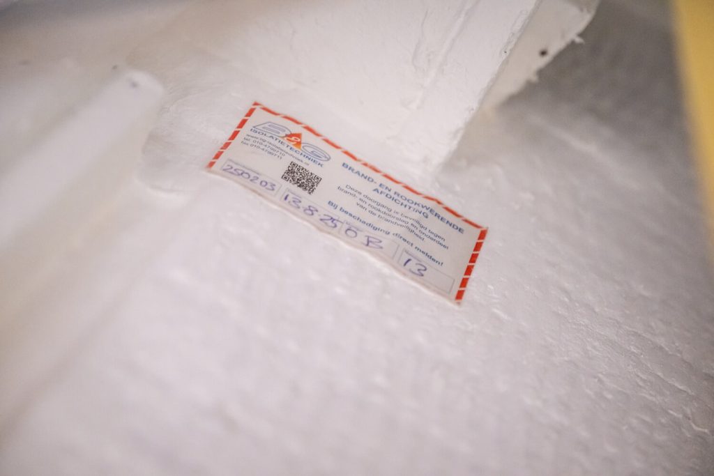 Brandveiligheidscertificaat op wit metselwerk.